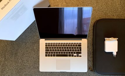 MacBook Pro mit Schutzhülle und Netzteil